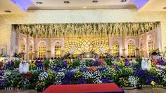 an elaborate stage set up with flowers and greenery for a wedding or special event