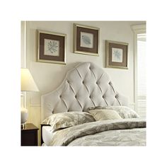 an upholstered headboard is shown in this bedroom with white walls and bedding