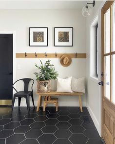 a black and white entryway with two chairs, a bench and a potted plant