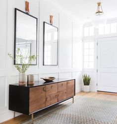 a living room with two mirrors on the wall and a table in front of it