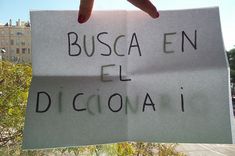 a person holding up a sign that says busca en el diccina i