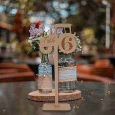 the table is set up with two mason jars and a wooden sign that says table 6