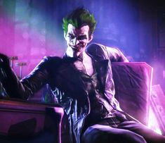 a man sitting on top of a couch in front of a purple light with green hair