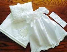 a white dress and matching diaper on a wooden table with two tags attached to it