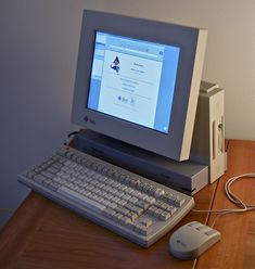 a desktop computer sitting on top of a wooden desk next to a keyboard and mouse