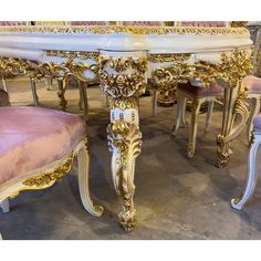 an ornately decorated dining table with pink velvet chairs