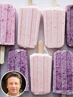 several popsicles are lined up on a white plate with purple and yellow toppings