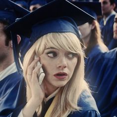 a woman talking on a cell phone while wearing a cap and gown