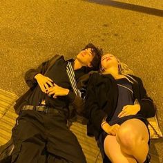 two people laying on the ground next to each other