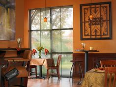 a dining room filled with lots of furniture and a piano in front of a window