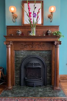 a fireplace in a living room with a mirror above it and flowers on the mantle