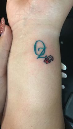 a woman's wrist with a small tattoo on the left side of her arm