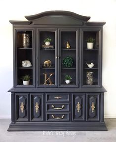 a black china cabinet with gold handles and drawers