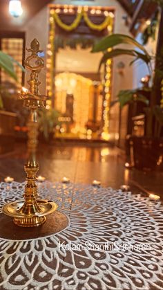 a candle holder sitting on top of a table in front of a decorated room with lights