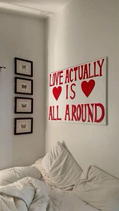 a bedroom with white walls and pictures on the wall