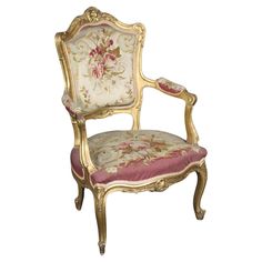 an ornately decorated chair with pink velvet upholstered on the armrests