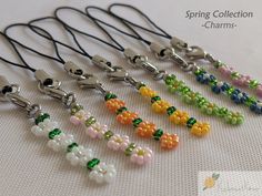 a collection of beaded necklaces are displayed on a white tablecloth with the words spring collection charms written below them