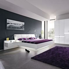 a modern bedroom with purple and white decor