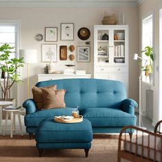 a living room filled with furniture and pictures on the wall next to a coffee table