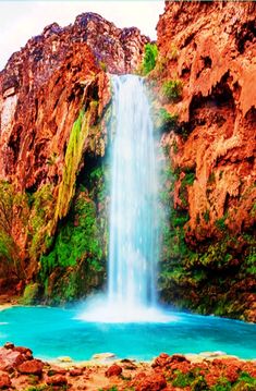 a waterfall in the middle of a body of water surrounded by rocks and greenery