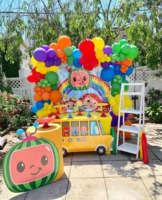 an outdoor play area with balloons and toys in the shape of children's vehicles