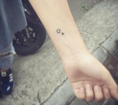 a small star tattoo on the wrist is shown in front of a person's hand