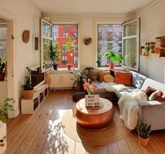 a living room filled with lots of furniture and plants on the windows sills