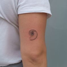 a woman's arm with a small tattoo on the left side of her arm