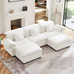 a large white sectional couch sitting on top of a hard wood floored living room