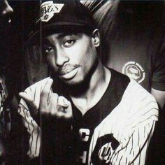 a black and white photo of a baseball player holding his hand up to the camera