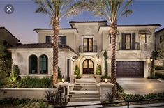 a large house with palm trees in the front yard and stairs leading up to it