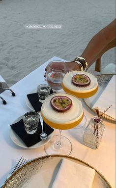 two desserts are sitting on a table by the water, ready to be served