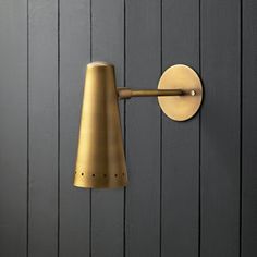 a wall mounted light on the side of a gray wooden wall next to a door