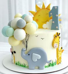 a birthday cake with an elephant, giraffe and balloon topper on it