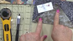 a woman's hand pointing at an origami piece