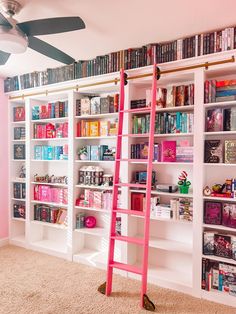 a pink ladder leaning against a white bookcase filled with books