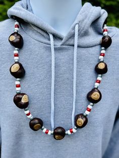 Football Helmet Pattern Buckeye Necklace - the new essential necklace for die-hard football fans! This necklace is your game day must-have, perfect for tailgates, family hangouts, and games at the Shoe. Get ready to flaunt your Buckeye pride with our classic pearl-finish pony bead style necklace. The scarlet, white, and gray beads capture the Ohio State spirit effortlessly. What sets our necklace apart? It's all about the Buckeyes - 14 top-notch, Columbus-grown Buckeyes, a cut above the rest. We Buckeye Necklace Diy, Buckeye Decorations, Crafts With Buckeyes, Buckeye Crafts Ideas, Buckeye Necklaces, Ohio State Crafts, Buckeye Crafts, Helmet Pattern, Ohio Buckeyes