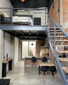 an open loft apartment with stairs leading up to the second floor