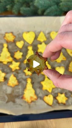 someone holding up a piece of food in front of a pan with hearts on it