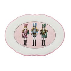 three nutcrackers on pink and white oval serving platter with pink border