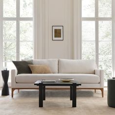 a living room filled with furniture and lots of window sill space next to a coffee table