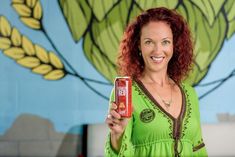 a woman holding up a can of beer