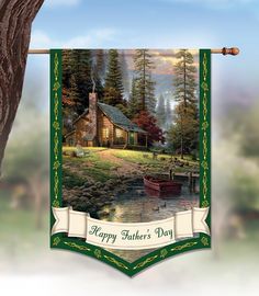 a happy father's day banner hanging from a tree with a boat in the water