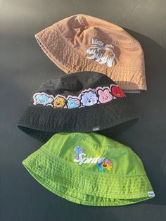 BTS hand embroidered and hand dyed bucket hats, perfect to rep your bias or your love for OT7! These are cotton bucket hats in a one size fits most sizing -Winter bear Taehyung V design on a light brown hat -BT21 baby design on a black bucket hat  -J-hope sprite design with hope world flower on a green bucket hat  Order your Hobi hat in time for lollapalooza! Playful Cotton Bucket Hat With Short Brim, Fun Short Brim Cotton Hats, Trendy Summer Bucket Hat With Embroidered Logo, Fun Cotton Hats For Streetwear, Playful Cotton Bucket Hat, One Size, Summer Bucket Hat With Embroidered Logo For Streetwear, Summer Streetwear Bucket Hat With Embroidered Logo, Cute Handmade Cotton Hat, Trendy Cotton Hat For Festivals