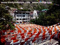 many orange and white chairs are lined up in front of a building with flags on it