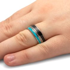 a person's hand with a ring on it and a turquoise stone in the middle