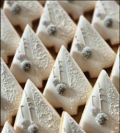 some white cookies with frosting on them are arranged in the shape of christmas trees