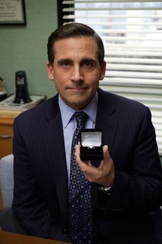 a man in a suit and tie holding an object