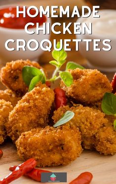 homemade chicken croquettes on a cutting board with sauces in the background