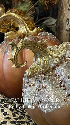 two pumpkins with gold and silver decorations on them